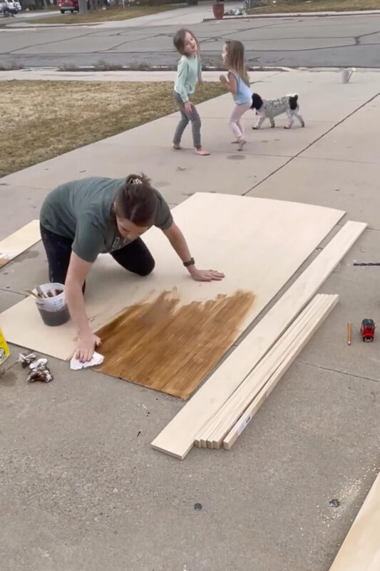 Applying stain to plywood.